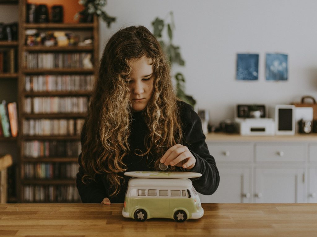 Mädchen in schwarzem Sweatshirt spielt mit Spielzeugauto